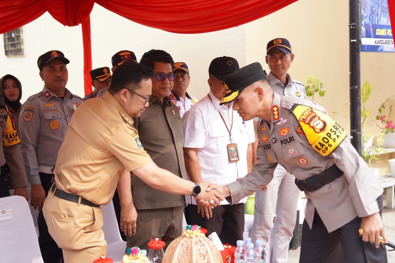 Plt Bupati Gowa Darmawangsyah Muin berjabat tangan dengan Kapolresta Gowa Kombes Pol Yusuf Usman saat Apel Gelar Pasukan Operasi Patuh 2026 di Kabupaten Gowa, Senin (26/10/2026).